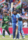 India's Rohit Sharma, center, celebrates with captain Virat Kohli, right, after scoring a century during the Cricket World Cup match between India and Pakistan at Old Trafford in Manchester, England, Sunday, June 16, 2019. (AP Photo/Aijaz Rahi)