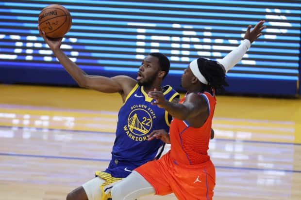 Andrew Wiggins, left, pictured driving to the basket against Oklahoma City Thunder's Luguentz Dort on May 8, will have to play a big role if Canada hopes to qualify for the Tokyo Olympics.  (Jed Jacobsohn/Associated Press - image credit)