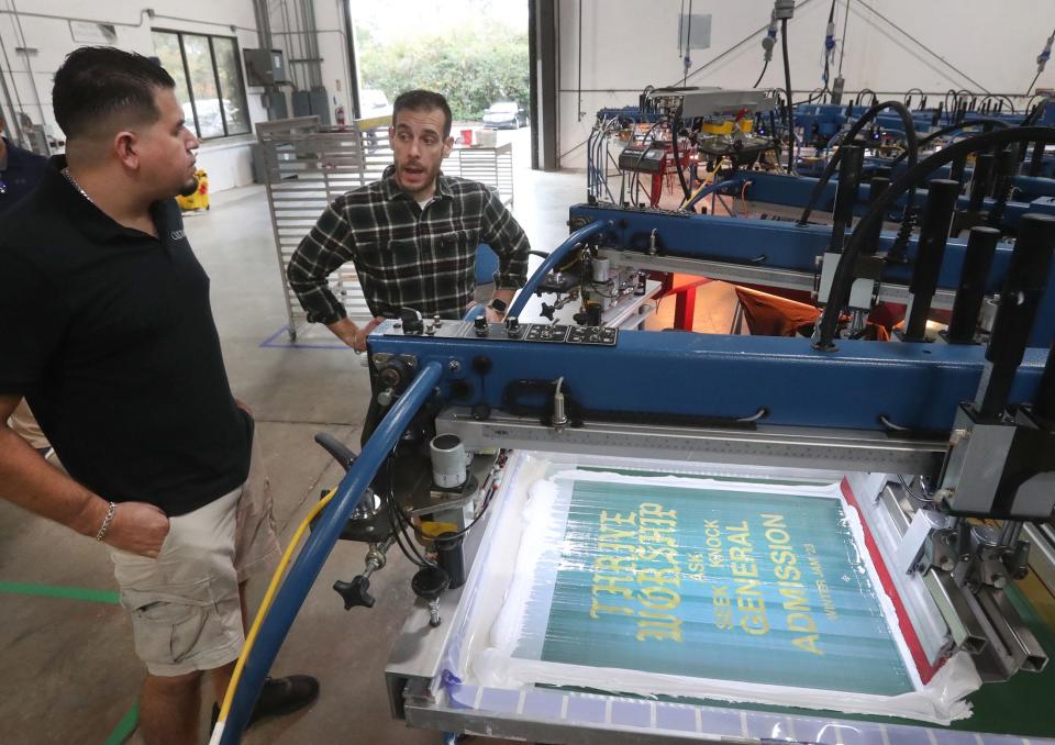 Arturo Garcia, left, production manager, and Chief Operating Officer Joey Santo, chat at Chicago-based Culture Studio's new Daytona Beach custom apparel manufacturing plant on Thursday, Jan. 5, 2023.