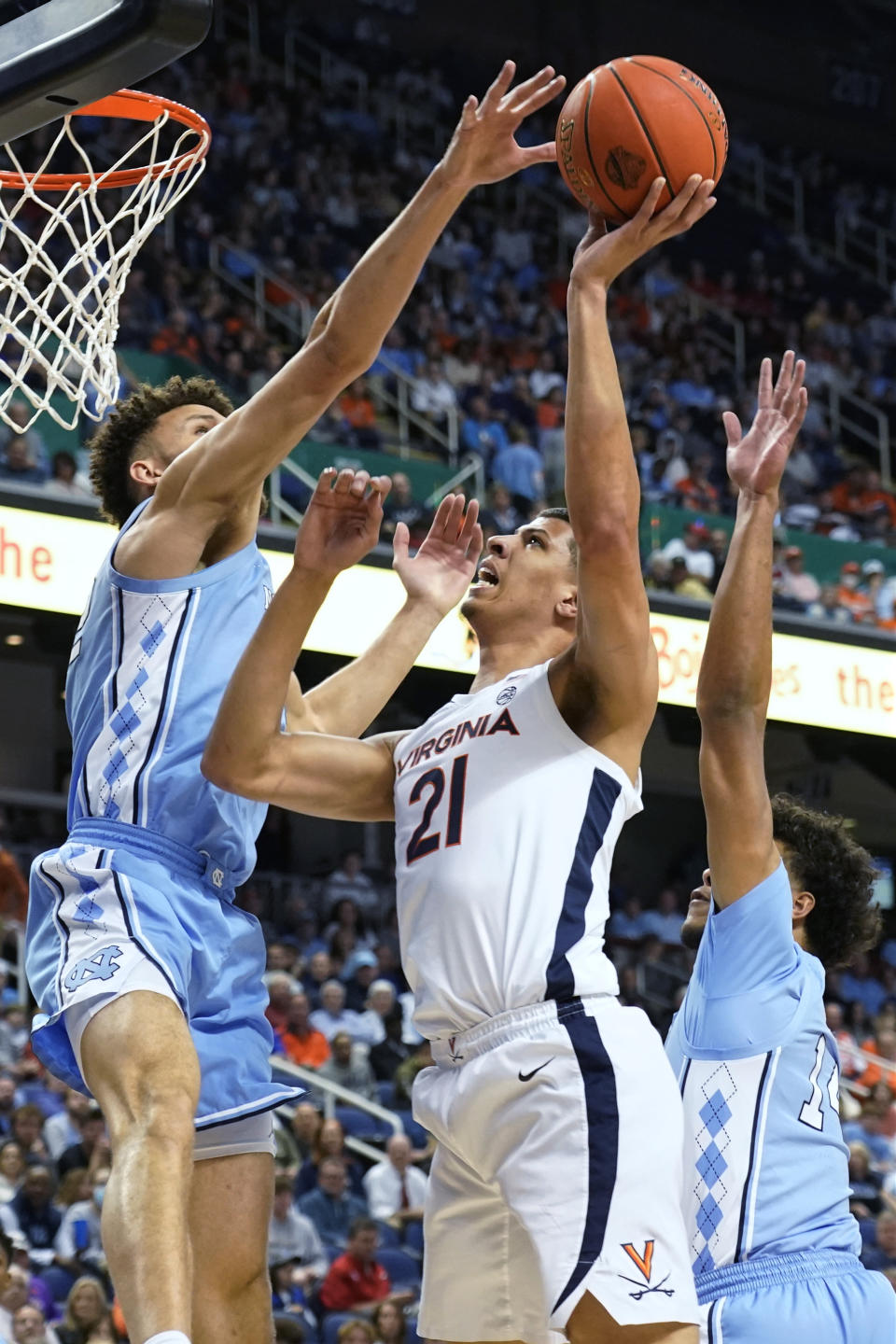 Virginia forward Kadin Shedrick (21) has his shot blocked by North Carolina forward Pete Nance, left, during the first half of an NCAA college basketball game at the Atlantic Coast Conference men's tournament in Greensboro, N.C., Thursday, March 9, 2023. (AP Photo/Chuck Burton)