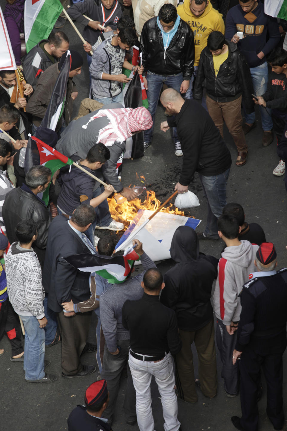 Jordanian protesters affiliated with Jordan's Muslim Brotherhood against U.S. Secretary of State John Kerry's peace talks burn a representation of the Israeli flag during a demonstration in downtown Amman, Jordan, Friday, Feb. 14, 2014. Hours before Jordan's King Abdullah II met with U.S. President Barack Obama in California, his Islamist opposition at home has staged its largest protest in several months to reject a peaceful Mideast settlement. (AP Photo/Mohammad Hannon)