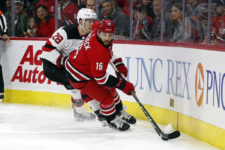 Carolina Hurricanes' Vincent Trocheck (16) controls the puck near New Jersey Devils' Damon Severson (28) during the second period of an NHL hockey game in Raleigh, N.C., Thursday, April 28, 2022. (AP Photo/Karl B DeBlaker)