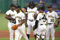 Pittsburgh Pirates starting pitcher Roansy Contreras (59) heads to the dugout after handing the ball to manager Derek Shelton, third from left, during the second inning of the team's baseball game against the Milwaukee Brewers in Pittsburgh, Friday, July 1, 2022. (AP Photo/Gene J. Puskar)