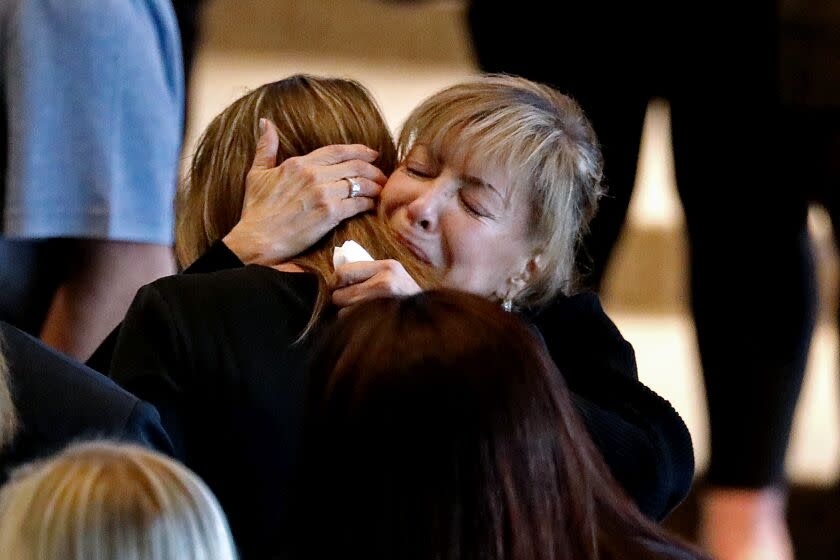GARDEN GROVE, CA - FEBRUARY 11: Stella Blair, right, mother of Elliot Blair, is consoled during a public memorial in honor of Elliot Blair, a 33-year-old public defender from Orange County, who was allegedly killed in Baja California last month, held at Christ Cathedral Arboretum on Saturday, Feb. 11, 2023 in Garden Grove, CA. Blair was celebrating his first wedding anniversary with wife Kimberly Williams. (Gary Coronado / Los Angeles Times)