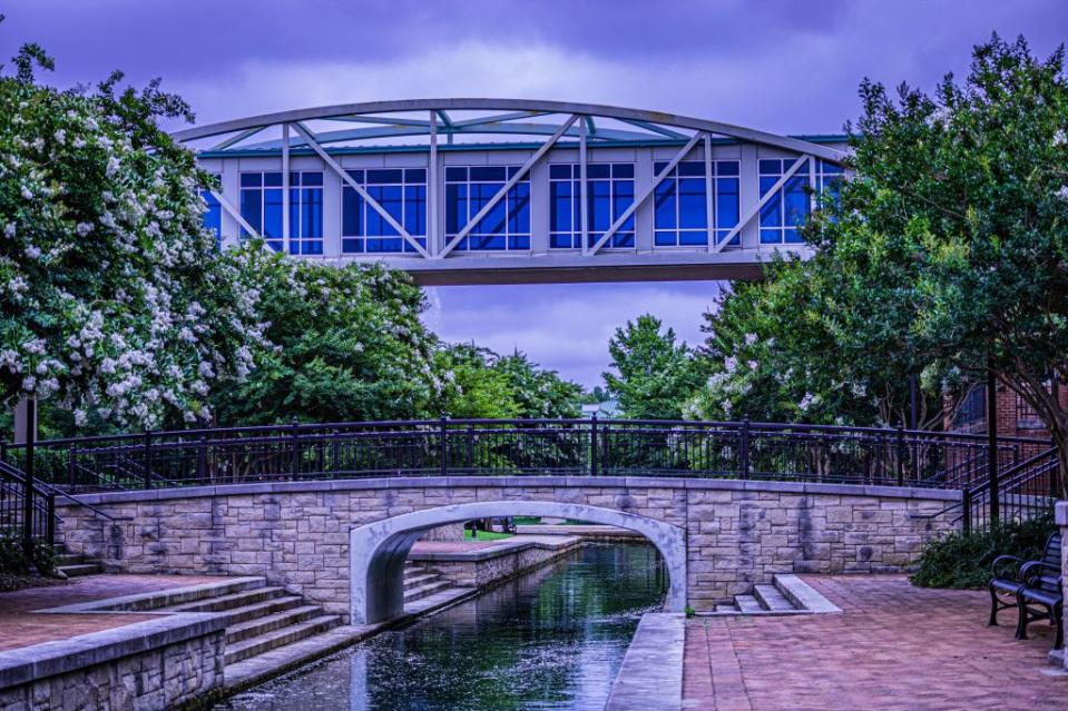 A metal enclosed walkway bridge in Big Spring International Park Huntsville, Alabama via Getty Images