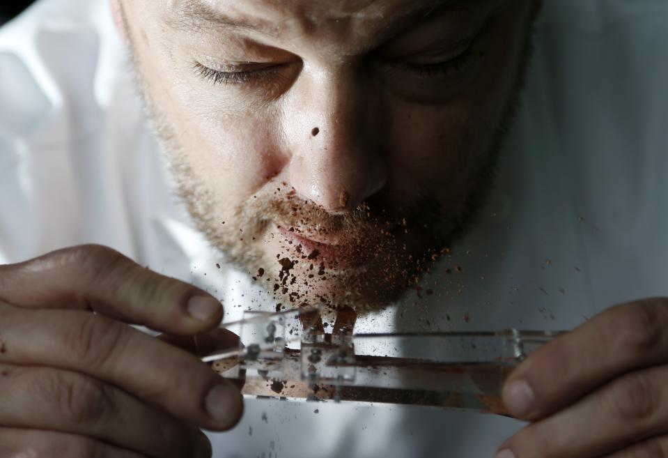 Belgian chocolatier Dominique Persoone snorts cocoa powder off his Chocolate Shooter in his factory in Bruges, February 3, 2015. When Belgian chocolatier Dominique Persoone created a chocolate-sniffing device for a Rolling Stones party in 2007, he never imagined demand would stretch much beyond the rock 'n' roll scene. But, seven years later, he has sold 25,000 of them. Inspired by a device his grandfather used to propel tobacco snuff up his nose, Persoone created a 'Chocolate Shooter' to deliver a hit of Dominican Republic or Peruvian cocoa powder, mixed with mint and either ginger or raspberry. Picture taken on February 3, 2015. REUTERS/Francois Lenoir (BELGIUM - Tags: FOOD SOCIETY)