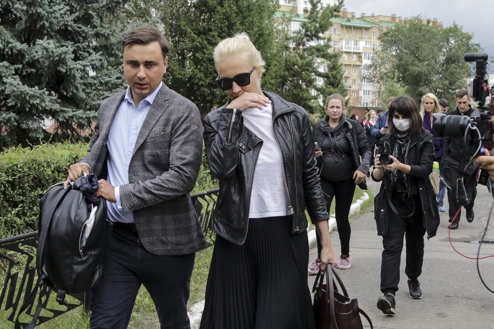 FILE - In this file photo taken on Friday, Aug. 21, 2020, Alexei Navalny's wife Yulia, center, and colleague Ivan Zhdanov, left, arrive at the Omsk Ambulance Hospital No. 1, where Navalny was hospitalized in Omsk, Russia. Attempts over the years to silence Navalny have all failed so far. Now he is in a coma in a Berlin hospital after suffering what German authorities say was a poisoning with a chemical nerve agent while traveling in Siberia on Aug. 20. (AP Photo/Evgeniy Sofiychuk, File)