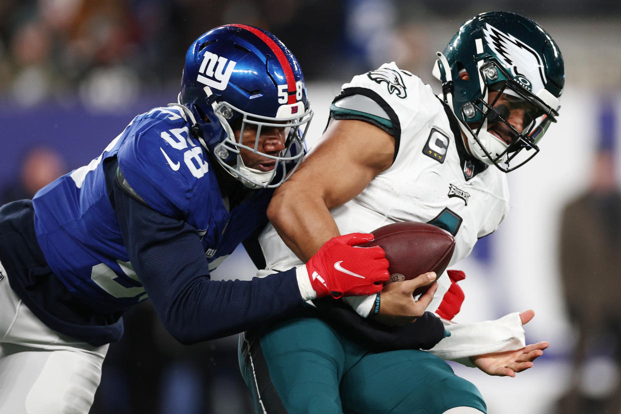 EAST RUTHERFORD, NEW JERSEY - JANUARY 07: Jalen Hurts #1 of the Philadelphia Eagles is tackled by Bobby Okereke #58 of the New York Giants during the second quarter at MetLife Stadium on January 07, 2024 in East Rutherford, New Jersey. (Photo by Elsa/Getty Images)