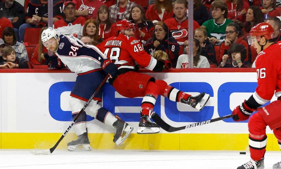 Columbus right wing Mathieu Olivier (24) and Carolina left wing Jordan Martinook (48) tangle up during the first period of the Carolina Hurricanes game against the Columbus Blue Jackets at PNC Arena in Raleigh, N.C., Wednesday, Oct. 12, 2022.
