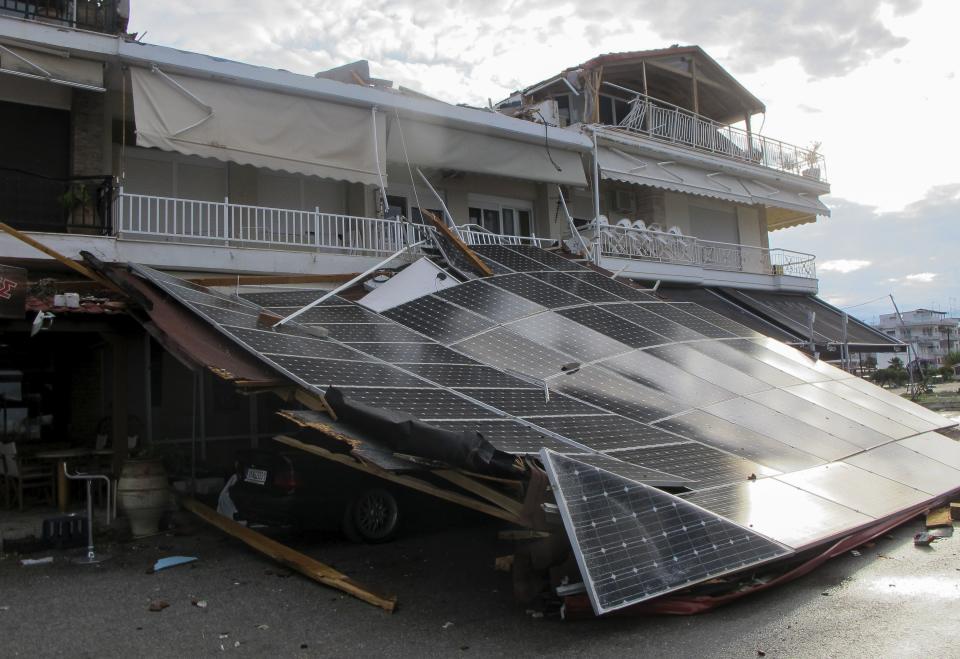 A car is seen under an outdoor shop's lean-to roof after a storm at Nea Plagia village in Halkidiki region, northern Greece on Thursday, July 11, 2019. A powerful storm hit the northern Halkidiki region late Wednesday. (Giannis Moisiadis/InTime News via AP)