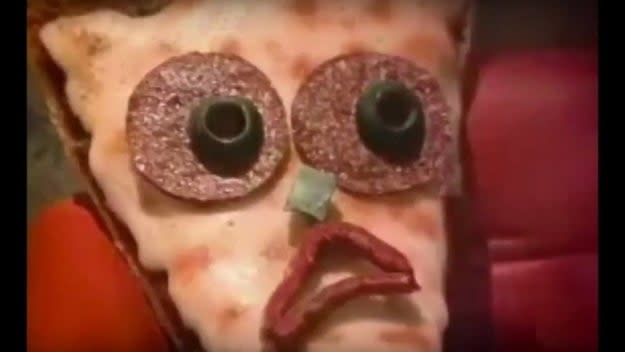 Person in a unique pizza-themed costume with large pepperoni eyes and a mouth