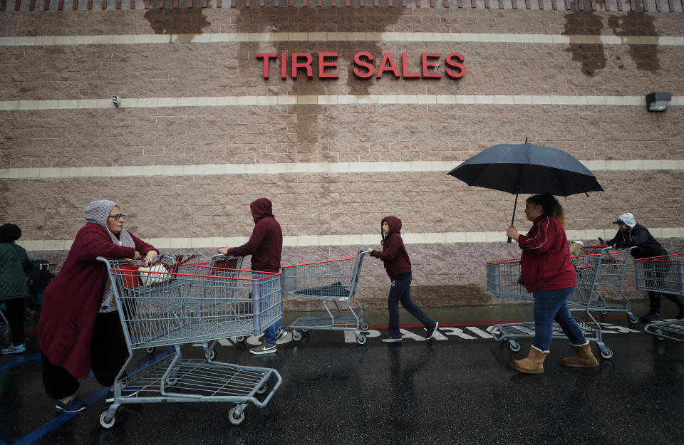 GLENDALE, CALIFORNIA - 14 MARTIE: Oamenii împing cărucioarele de cumpărături la coadă în ploaie în timp ce așteaptă să intre într-un magazin Costco Wholesale pe 14 martie 2020 în Glendale, California. Linia avea sute de cumpărători, dar s-a mișcat destul de ușor, iar cumpărătorii au putut în cele din urmă să intre în magazin pentru a face cumpărături. Statul California raportează cel puțin 247 de cazuri confirmate de COVID-19, cu cinci decese. Mulți alții poartă coronavirus, dar nu au fost testați, potrivit oficialilor. (Fotografia de Mario Tama/Getty Images)