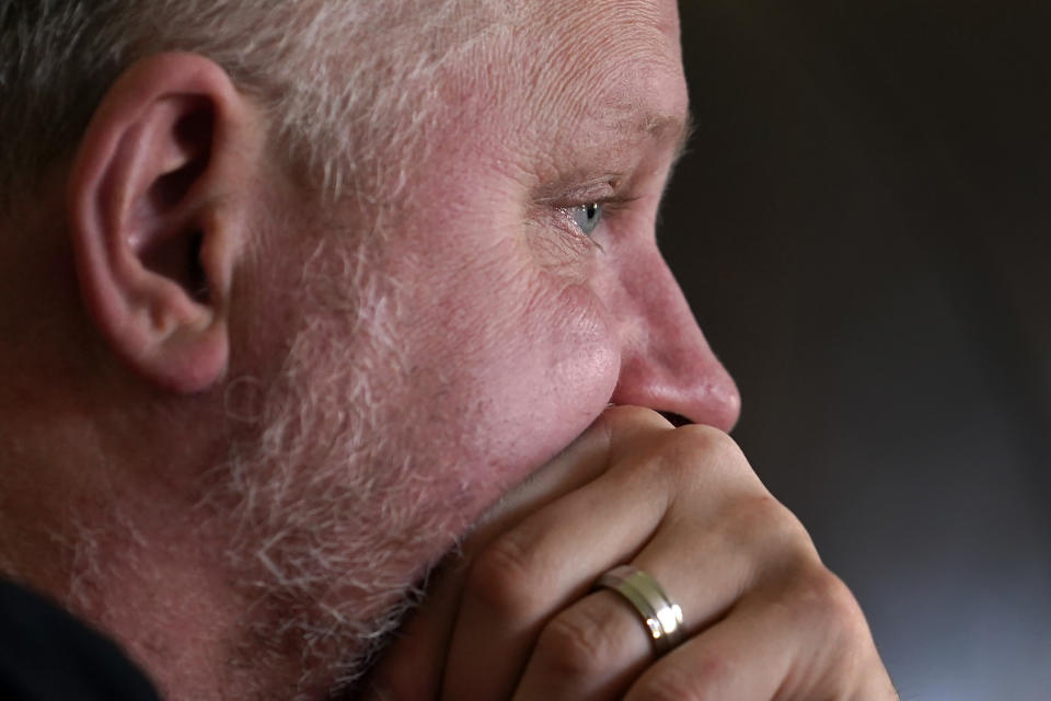 Rodney Wegg's eye tears up as he listens to his wife Kari, talk about her COVID-19 ordeal that resulted in a double-lung transplant during an interview with The Associated Press in their Westfield, Ind., home on Sunday, March 21, 2021. "I feel like I'm trapped in a Lifetime movie," he posted to co-workers, friends and relatives following Kari's case. "So much information, so many paths to take, so many decisions to make not knowing where they'll lead." And the most painful decision, one doctor warned in an August call with Rodney and his wife's siblings, was days away: whether to disconnect Kari from the machine keeping her alive. (AP Photo/Charles Rex Arbogast)