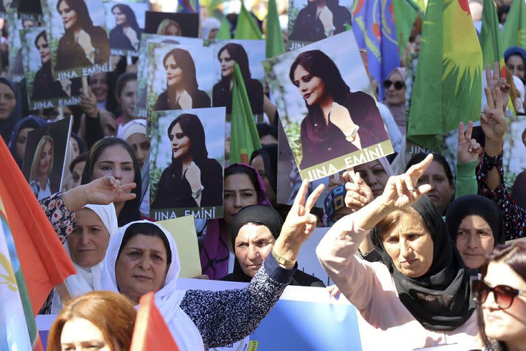 En esta foto proveída por la agencia kurda Hawar News Agency, mujeres kurdas llevan retratos de la iraní Mahsa Amini en una protesta por su asesinato en Irán, realizada en la ciudad iraquí de Qamishli el 26 de septiembre del 2022.  (Hawar News Agency vía AP)