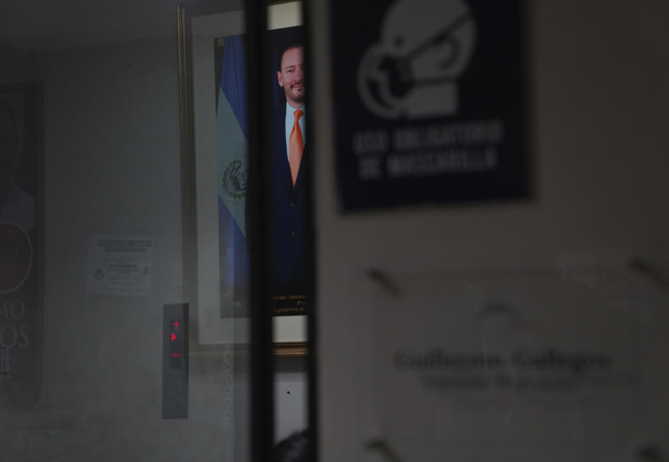 A portrait of lawmaker Guillermo Gallegos is seen through a window in his office, on Monday, May 16, 2022, in San Salvador, El Salvador. Lawmakers voted last year to uphold the country’s abortion ban, one of the world’s strictest, with some citing Scripture. Gallegos is outwardly against abortion, saying that it goes against his Christian faith. (AP Photo/Jessie Wardarski)