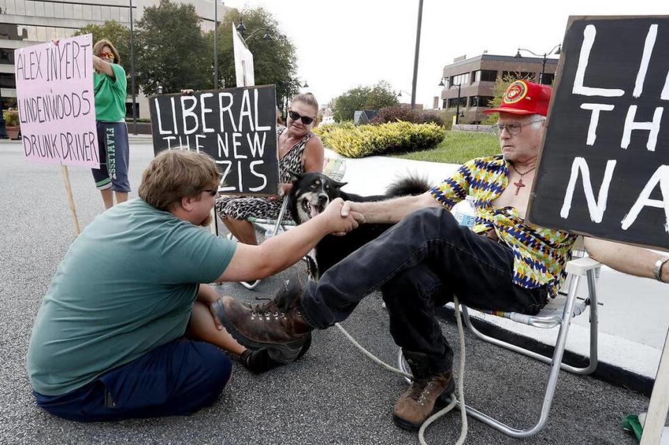 A man shakes hands with Stewart Lannert, of Belleville, seated in lawn chair, as Lannert and others protest against “liberals” and former St. Clair County Public Defender Alex Enyart in 2017. Steve Nagy/snagy@bnd.com