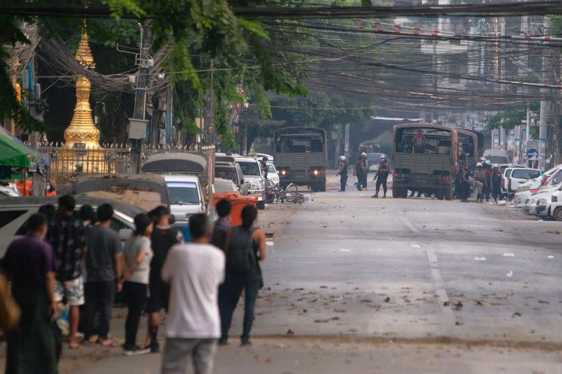 People look at a police vehicle after Sanchaung district has been seized in search of anti-coup demonstrators in Yangon