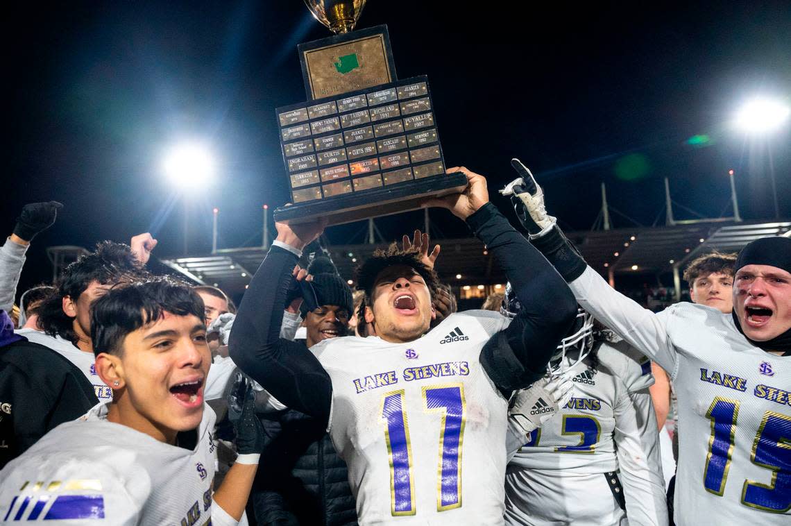 Lake Stevens’ Jayden Limar hoists the championship trophy after the Vikings beat Kennedy Catholic, 24-22, in the Class 4A state title game on Saturday, Dec. 3, 2022, at Mount Tahoma High School in Tacoma, Wash.