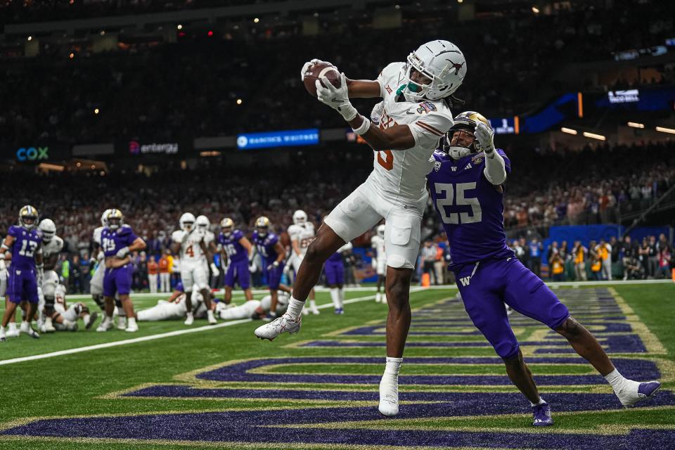 Texas Longhorns wide receiver Adonai Mitchell makes a touchdown catch over Washington cornerback Elijah Jackson during the Sugar Bowl in the College Football Playoff semifinal at the Caesars Superdome on Jan. 1 in New Orleans. The catch would be the last touchdown for the Longhorns in the 37-31 loss to Washington.