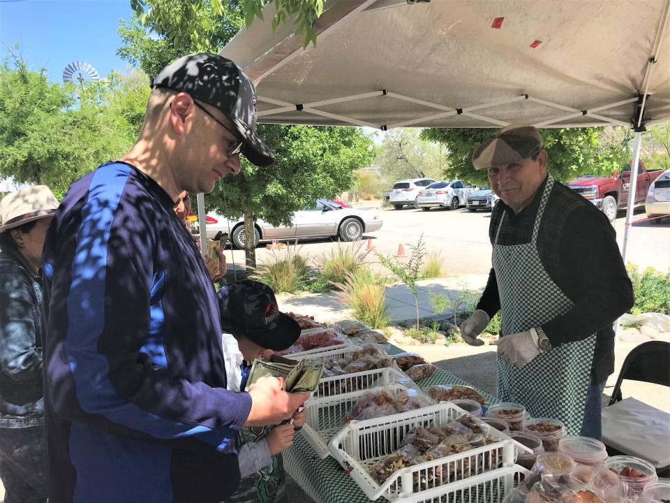 Bob Salcedo, owner of Mexican Delicious, helped a customer with his purchase of dehydrated sweet potato chips at the Ardovino's farmers market in 2019.