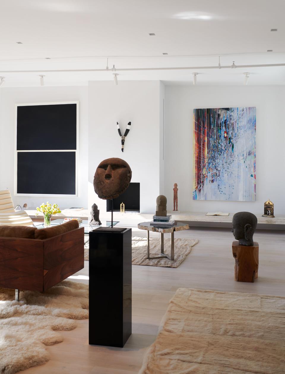 Pieces by (from left) Richard Serra, Gabriel Orozco, and Sarah Sze hang on the living room walls. In foreground, a West African mask on stand.