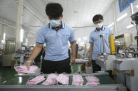 Workers arrange face masks to protect against the coronavirus at a mask factory where U.S. Health and Human Services Secretary Alex Azar visited during an inspection tour in New Taipei City, Taiwan, Wednesday, Aug. 12, 2020. (AP Photo/Chiang Ying-ying)