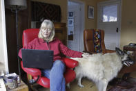 Susan Crowley, a 75-year-old retired attorney, works on her laptop at her home with her dog, Mollie, at her side in Hood River, Ore., on Jan. 23, 2021. Crowley submitted public comments to Oregon's vaccine advisory committee to criticize the state's controversial decision to vaccinate its teachers and early childhood care givers ahead of its oldest residents. Teachers in Oregon are eligible for the vaccine this week, two weeks ahead of the state's oldest residents and more than a month ahead of those between age 65 and 70. Oregon's decision underscores the difficult moral dilemma facing local and state public health officials as they weigh which populations need the vaccine most urgently amid a nationwide dose shortage. (AP Photo/Gillian Flaccus)