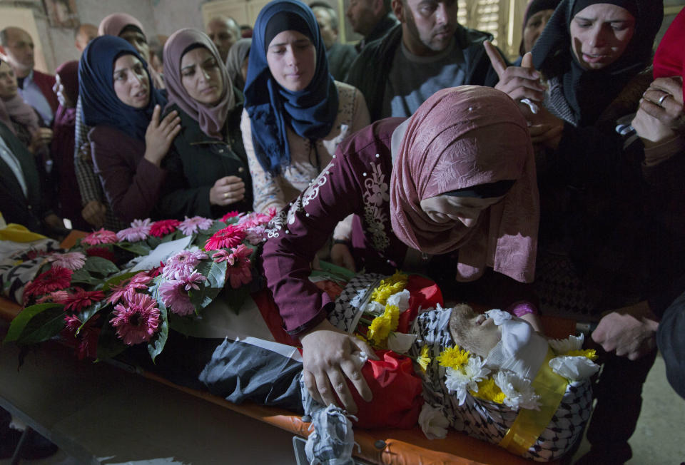 Mourners take a last look at the body of Palestinian Mohammed Shreteh during his funeral in the West Bank village of Mazraa al-Gharbiya, near Ramallah, Sunday, Nov. 11, 2018. Shreteh succumbed to his wounds that were sustained during clashes with Israeli soldiers in the village last month. (AP Photo/Nasser Nasser)