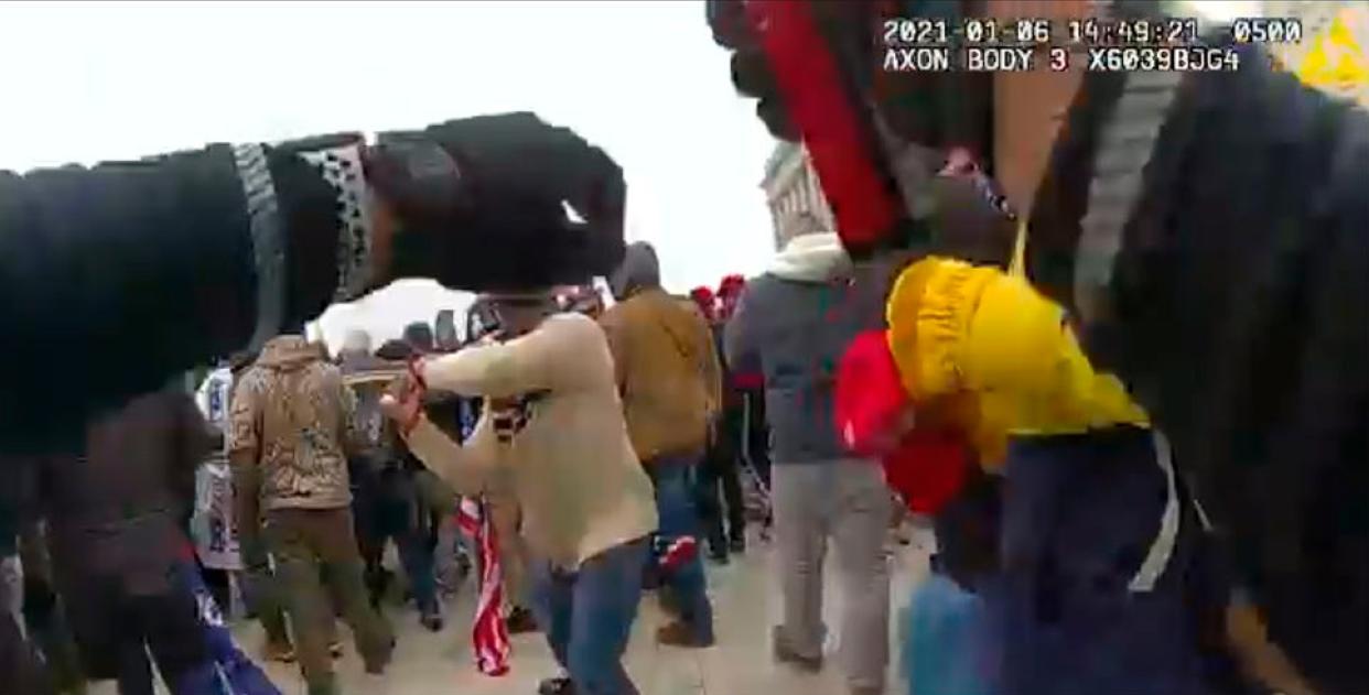 In this image from a Washington Metropolitan Police Department officer's body-worn video camera, and contained in the statement of facts supporting an arrest warrant for Mark Ponder, Ponder strikes an officer with a pole on the West Front of the U.S. Capitol on Jan. 6, 2021, in Washington. 