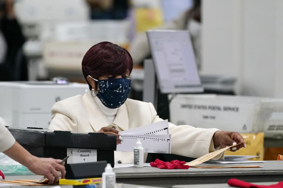 FILE - In this Nov. 4, 2020 file photo, absentee ballots are processed at the central counting board in Detroit. This year, Republicans across the country have zeroed in on mail voting and enacted new limits on a process that exploded in popularity during the pandemic. (AP Photo/Carlos Osorio, File )