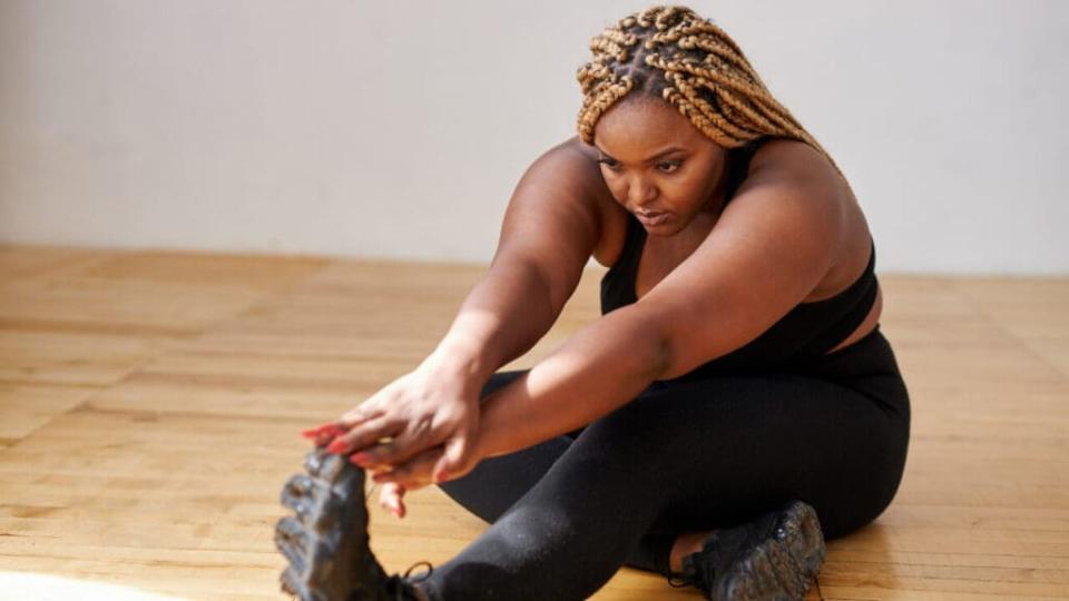 Black woman stretches before workout