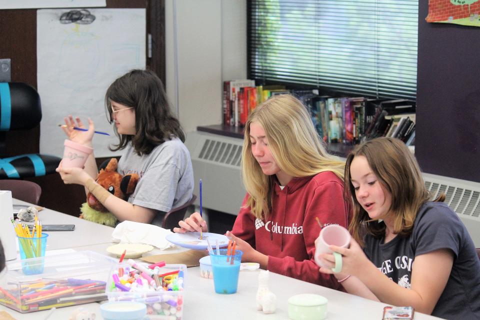 A group of students working on painting pottery pieces during a Project Term course.