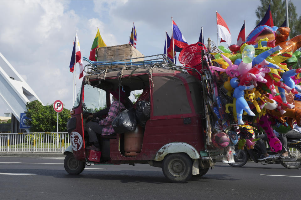 A motorized rickshaw drives past the Association of Southeast Asian Nations (ASEAN) flags advertising the upcoming its summits near Phnom Penh International Airport in Phnom Penh, Cambodia, Tuesday, Nov. 8, 2022. Southeast Asian leaders convene in the Cambodian capital Thursday, faced with the challenge of trying to curtail escalating violence in Myanmar while the country’s military-led government shows no signs of complying with the group’s peace plan. (AP Photo/Heng Sinith)