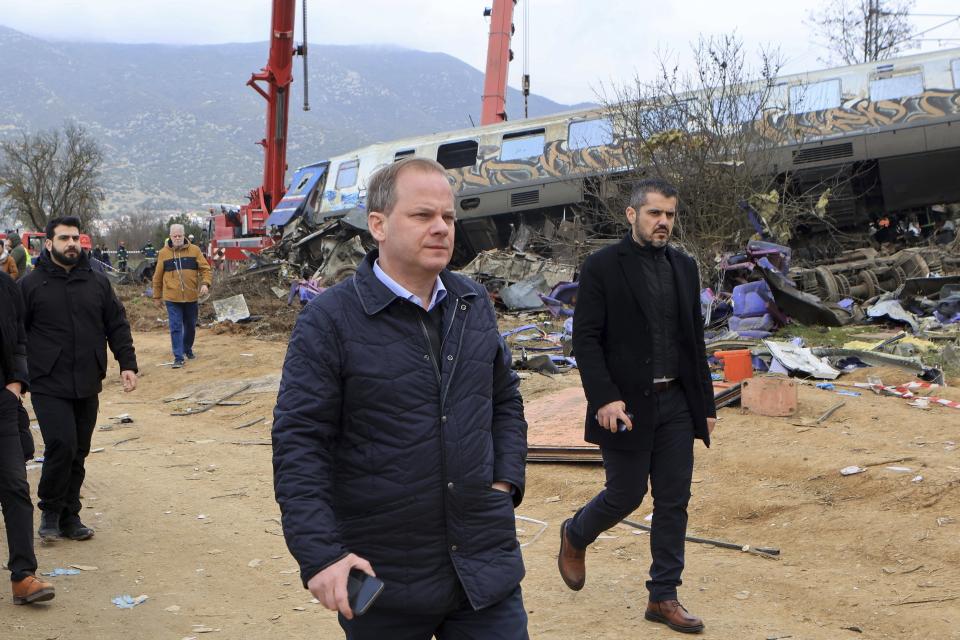 Transport Minister Kostas Karamanlis visits the location of a collision in Tempe, about 376 kilometres (235 miles) north of Athens, near Larissa city, Greece, Wednesday, March 1, 2023. Karamanlis resigned Wednesday, saying he felt it was his "duty" to step down. A passenger train carrying hundreds of people, including many university students returning home from holiday, has collided at high speed with an oncoming freight train. (George Kidonas/InTime News via AP)