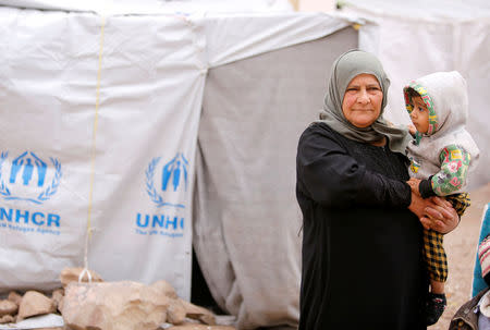 Amira Gharmoush holds her grandson at Herjelleh shelter in Damascus countryside, Syria March 30, 2018. REUTERS/Omar Sanadiki