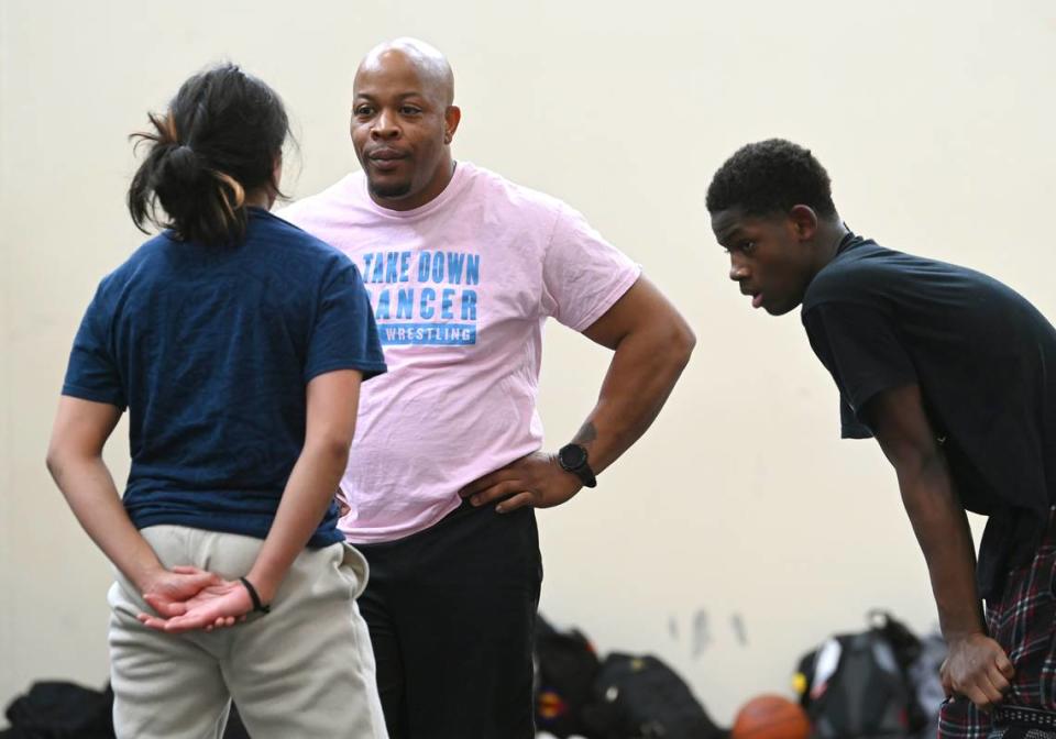 Mallard Creek High assistant coach Cameron Stinson Sr. speaks with a wrestler during practice on Wednesday, March 22, 2023. Stinson Sr.’s son, Cameron Stinson Jr. is a three-time state champion who has never lost a match. JEFF SINER/jsiner@charlotteobserver.com