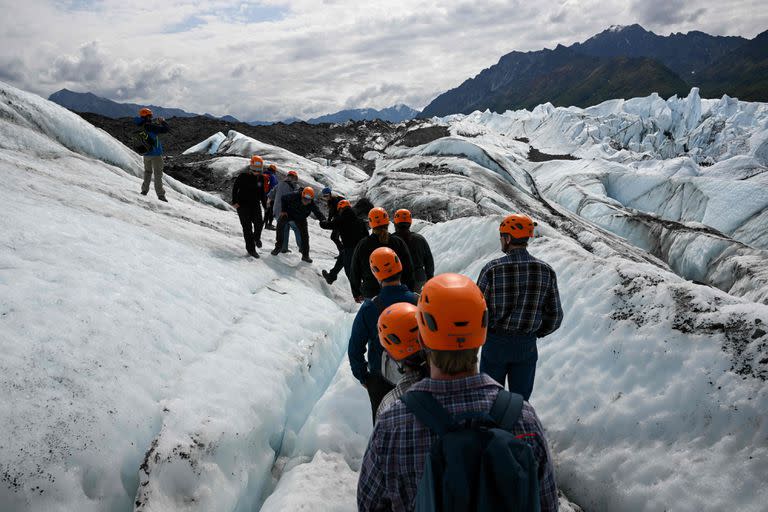 Los visitantes caminan sobre el hielo durante una visita guiada al glaciar Matanuska