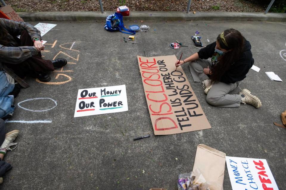 Cal Poly Humboldt student Lily, who did not share her last name, paints a sign Tuesday, April 23, 2024, outside Siemens Hall, which pro-Palestinian students and community members have occupied to call for a permanent ceasefire in Gaza.
