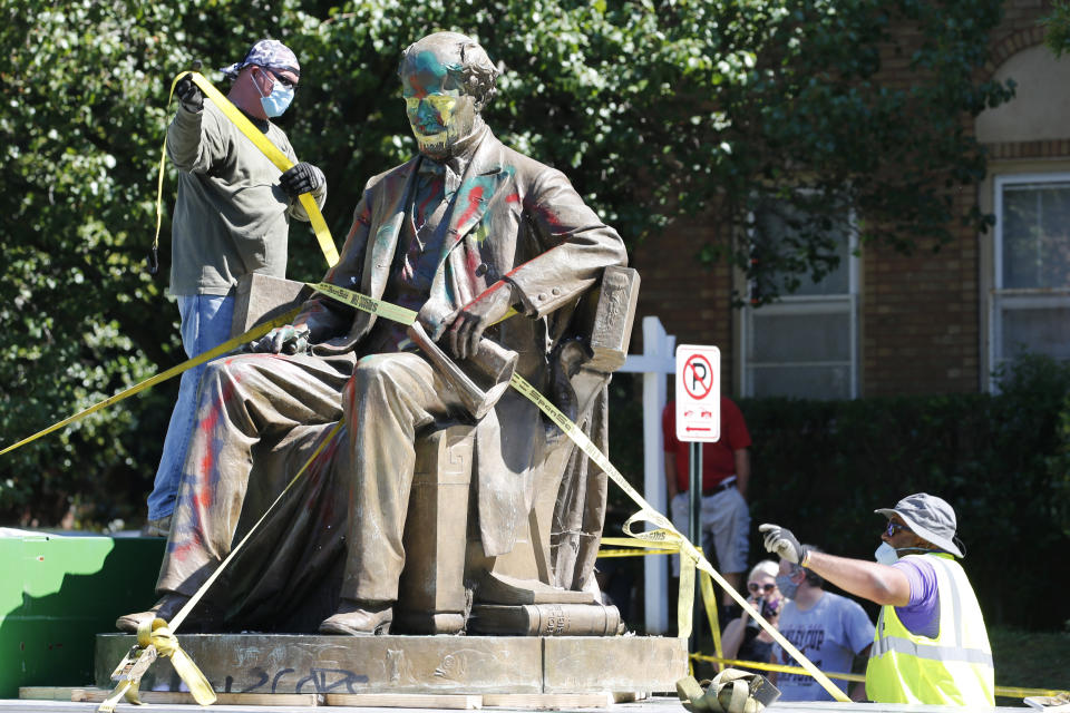 Workers secure the statue of Confederate Naval officer Matthew Fontaine Maury to a truck on Monument Avenue, Thursday, July 2, 2020, in Richmond, Va. Maury was better known for his work in oceanography and other sciences before the Civil War. His statue is the second removed since a new state law was enacted on July first. (AP Photo/Steve Helber)