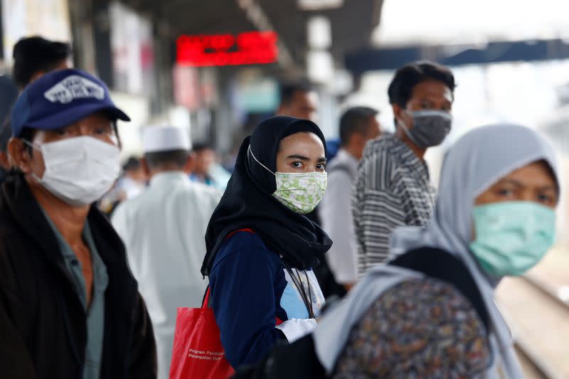 People with surgical masks look on at station Tanah Abang, following the outbreak of the coronavirus in China, in Jakarta