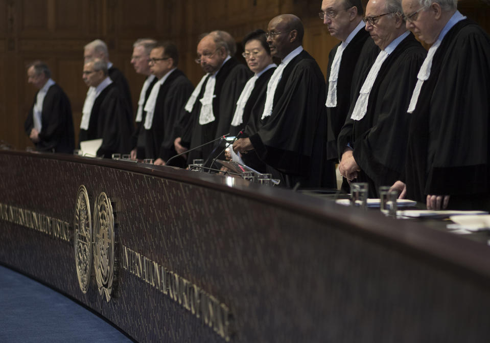 Presiding judge Abdulqawi Ahmed Yusuf of Somalia, fourth from right, and other judges take their seats prior to reading the court's verdict as delegations of Iran and the U.S. listen at the International Court of Justice, or World Court, in The Hague, Netherlands, Wednesday, Feb. 13, 2019. The court is scheduled to deliver its judgement on U.S. objections about the court's jurisdiction in the case. (AP Photo/Peter Dejong). (AP Photo/Peter Dejong)
