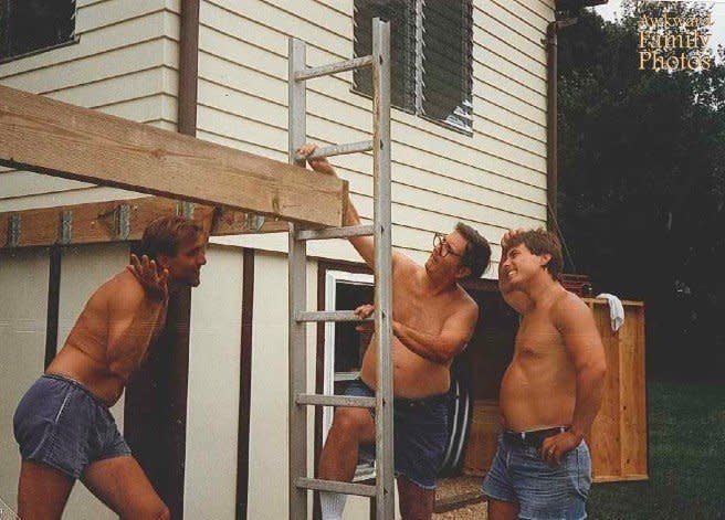 "In 1989 my dad (on the far right) grandfather (holding the ladder) and family friend were building a deck off the back of our house.  After they got the first boards up my mother said 'looks nice, but how are you going to get the ladder out?' They forgot to move the ladder before securing the last board for the frame!! They ended up cutting the ladder apart to get it out. Also, notice the awkwardness of the jean shorts."