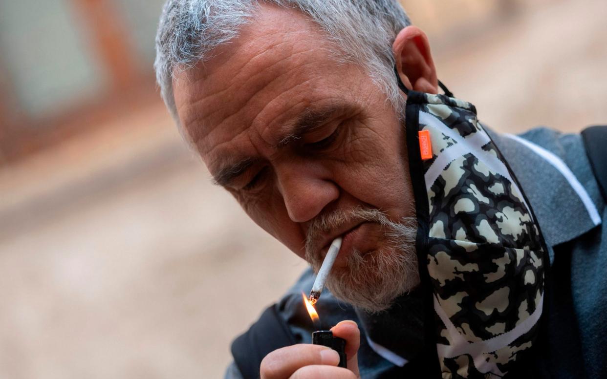 Smokers are prohibited from lighting up outdoors unless they can be sure to maintain a safe social distance - Jose Jordan/AFP