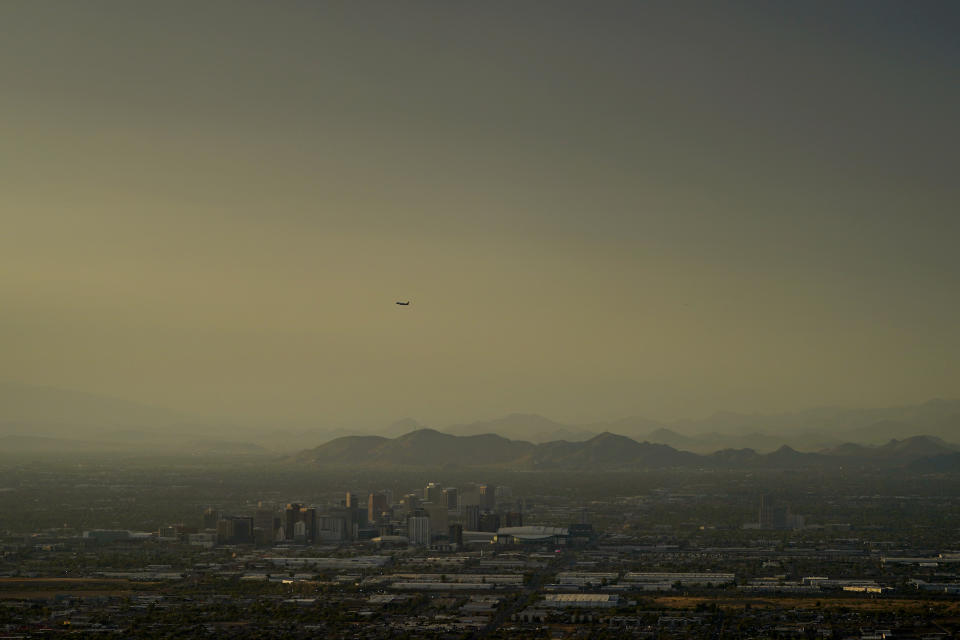 FILE - Clouds surround downtown Phoenix at sunset, Sunday, July 30, 2023. The European climate agency calculates that November, for the sixth month in a row, the globe set a new monthly record for heat, adding the hottest autumn to the broken records of record-breaking heat this year. (AP Photo/Matt York, File)