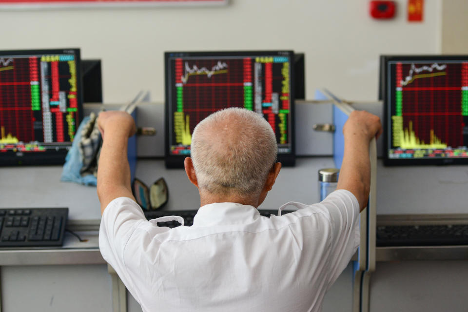 An investor looks at screens showing stock market movements at a securities company in Fuyang in China's eastern Anhui province on July 6, 2020. - Shanghai stocks surged on July 6 to a more than two-year high as investors piled in following a combination of rosy predictions for the market and strong economic data. (Photo by STR / AFP) / China OUT (Photo by STR/AFP via Getty Images)