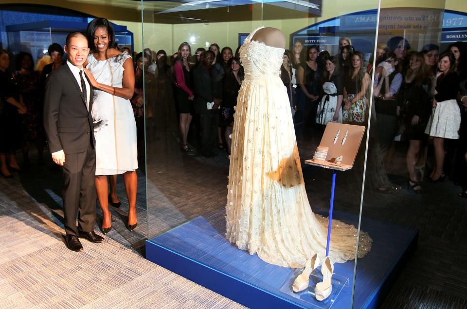 First lady Michelle Obama stands with designer Jason Wu in front of the gown she wore to the 2009 inaugural balls and is now  in the Smithsonian's Museum of American History, March 9, 2010 in Washington, D.C.