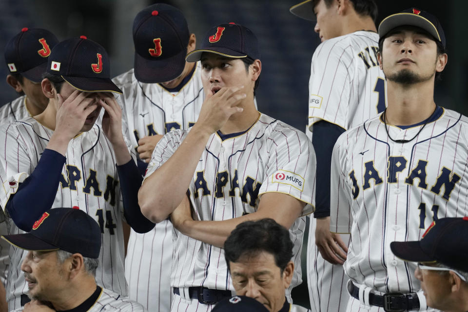 Japan's Shohei Ohtani, center, Yu Darvish, right, and Roki Sasaki, left, participate a group photo session before an official training session prior to the Pool B game at the World Baseball Classic (WBC) at the Tokyo Dome Wednesday, March 8, 2023, in Tokyo. (AP Photo/Eugene Hoshiko)