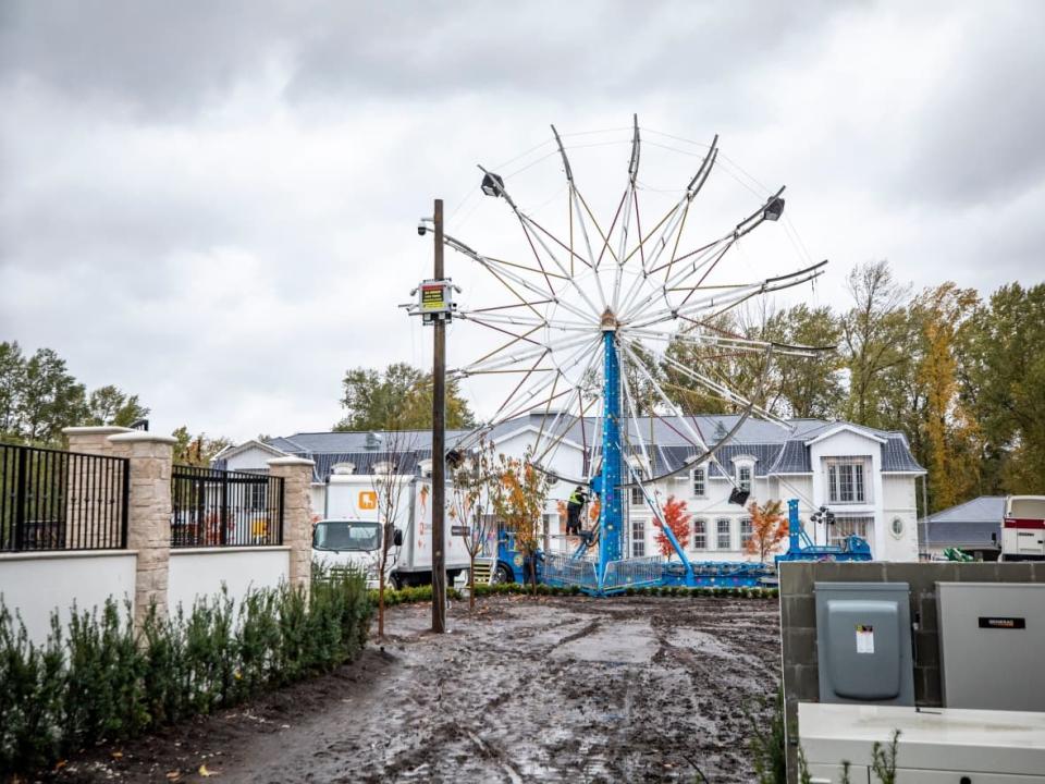 Crews work to dismantle a Ferris wheel in the front yard of a home in Surrey, British Columbia on Wednesday, October 20, 2021.  (Ben Nelms/CBC - image credit)