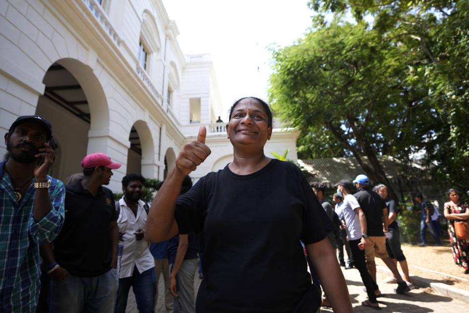 A protester displays the thumbs up as she vacates the presidential palace with other protesters in Colombo, Sri Lanka, Thursday, July 14, 2022. Protest leader Devinda Kodagode told The Associated Press they were vacating official buildings after the Parliament speaker said he was seeking legal options to consider since Rajapaksa left without submitting his resignation letter as promised. (AP Photo/Eranga Jayawardena)