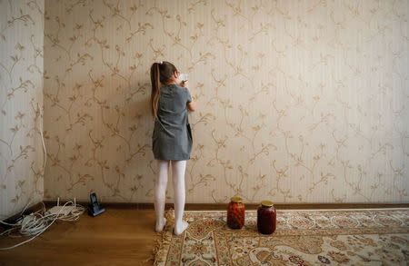 Dana, 8, granddaughter of Petr Smotrich, a furnace operator at Aksu Ferroalloys Plant since 1978, draws as she plays in her grandfather's apartment in the town of Aksu, north-eastern Kazakhstan, February 22, 2018. REUTERS/Shamil Zhumatov